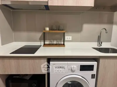 Modern kitchen with sleek countertop and built-in washing machine