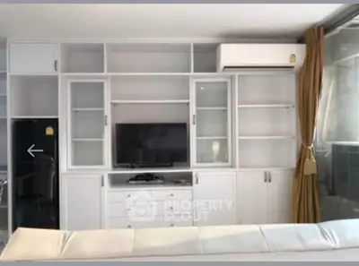 Modern living room with built-in white cabinetry and air conditioning unit