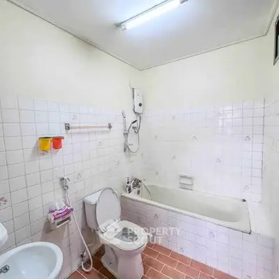 Spacious bathroom with bathtub and modern fixtures in a well-lit setting.