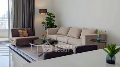 Elegant living room with modern furniture and city view balcony, perfect for urban living.