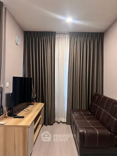 Cozy living room with modern decor, featuring a sleek TV setup and stylish curtains.