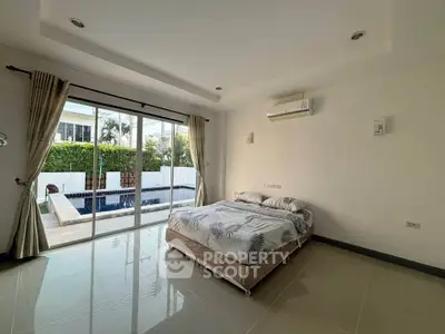 Spacious bedroom with pool view and modern decor in luxury home