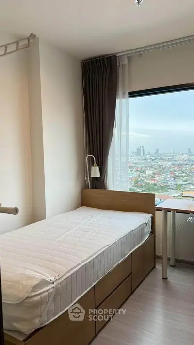 Cozy bedroom with single bed and city view, perfect for urban living.