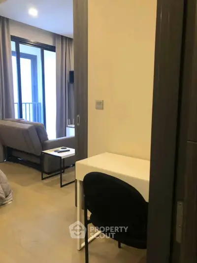Modern apartment interior with cozy living room and study area, featuring a small balcony.