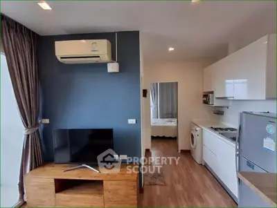 Modern apartment interior with living room and kitchen featuring air conditioning and washing machine.