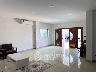 Spacious living room with modern decor and large wooden doors