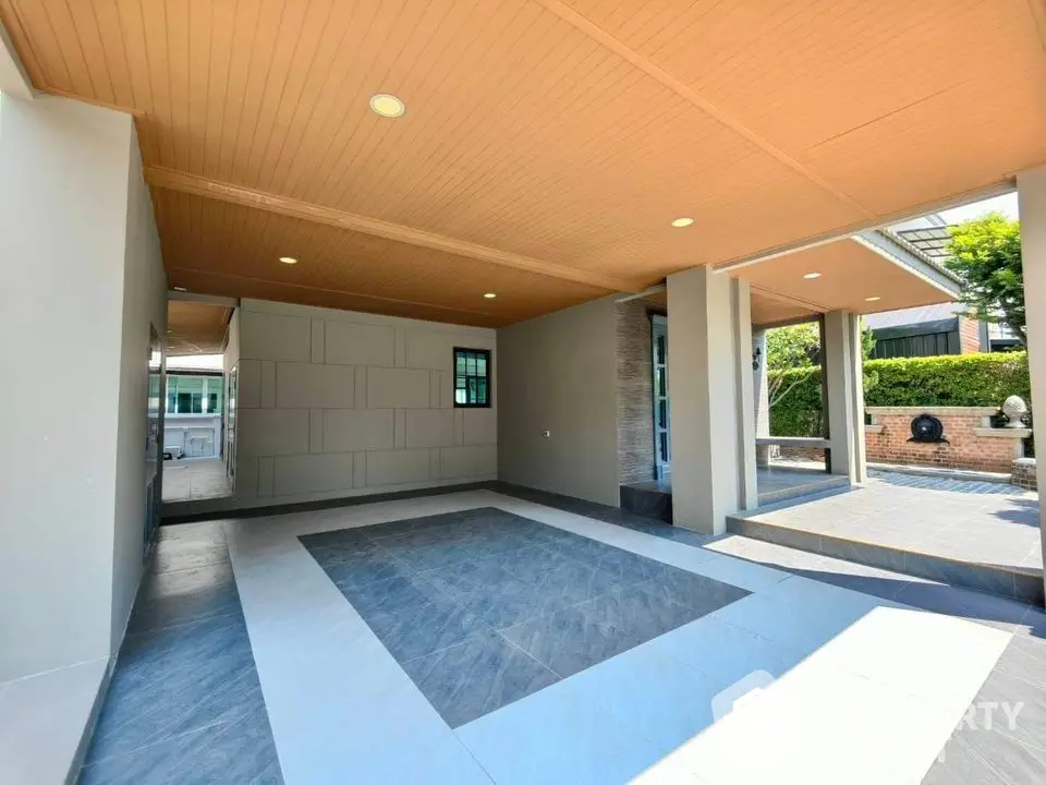 Spacious modern carport with elegant tile flooring and wooden ceiling in a luxury home