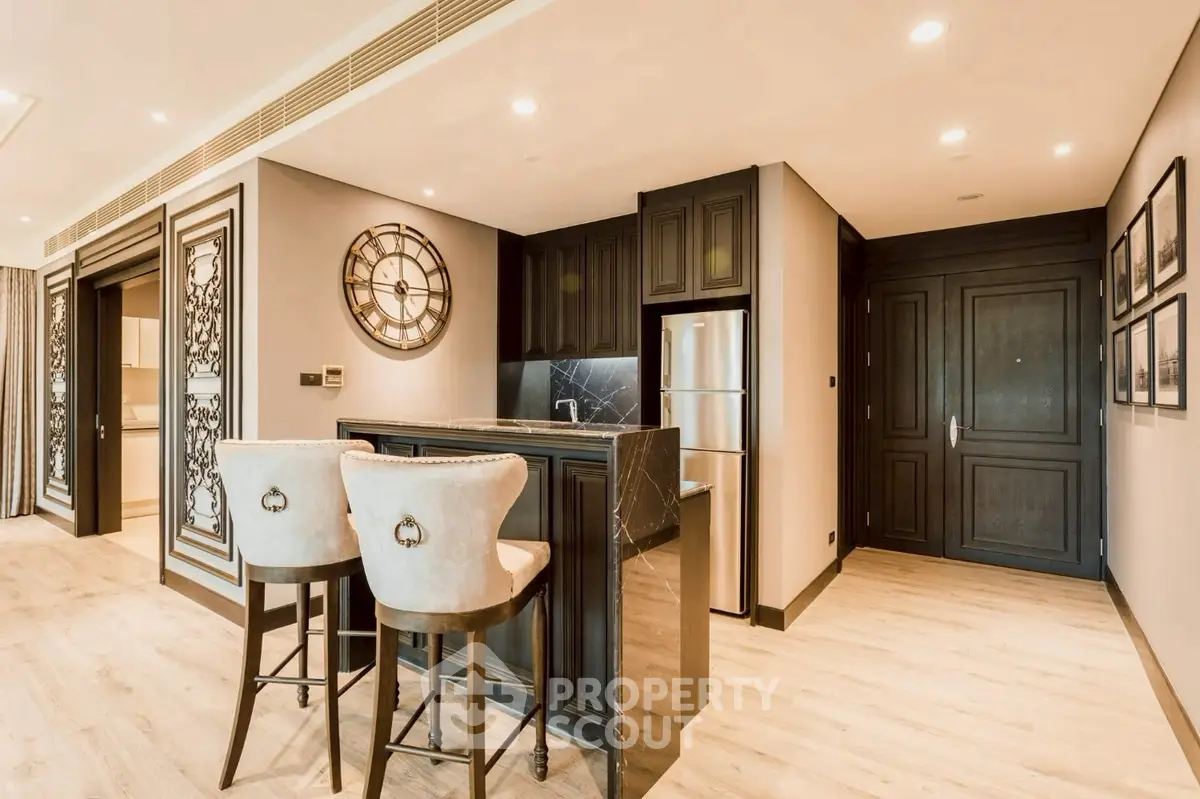 Luxurious open kitchen with elegant bar seating and modern appliances in a stylish apartment.
