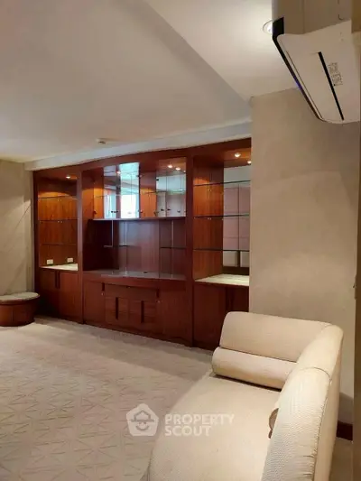 Spacious living room with elegant built-in wooden cabinetry and modern air conditioning.