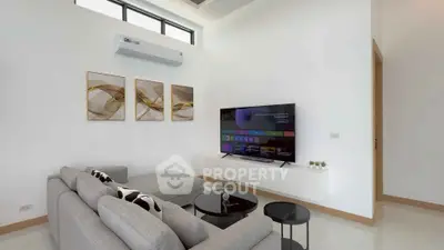 Modern living room with sleek furniture and wall-mounted TV in a bright, airy space.
