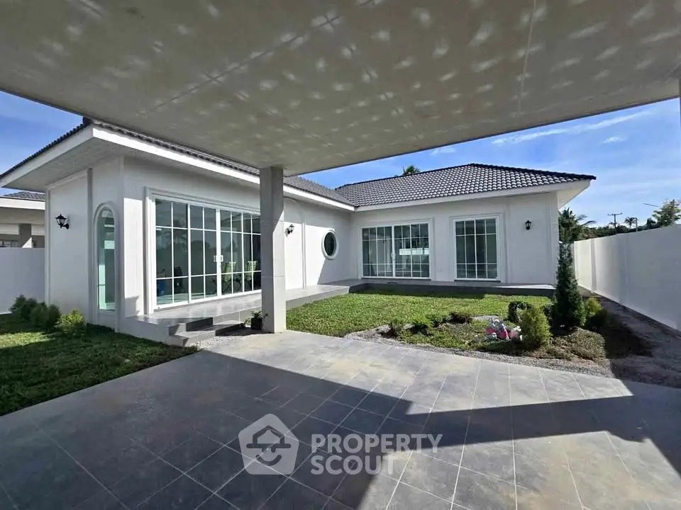Modern single-story home with spacious patio and large windows, perfect for natural light and outdoor living.