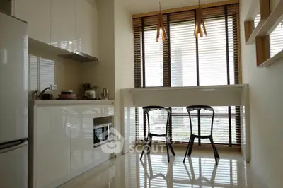 Modern kitchen with sleek design, featuring large windows and stylish dining area.