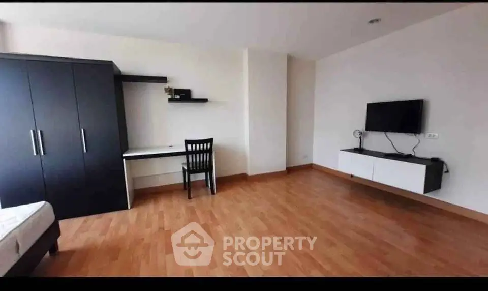 Spacious modern living room with wooden flooring and wall-mounted TV