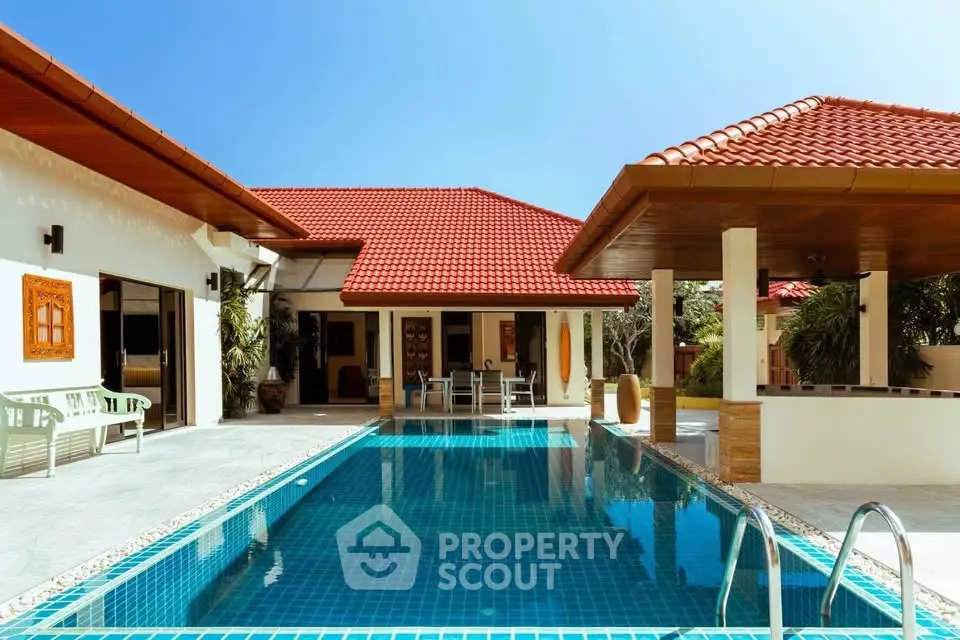 Luxurious villa with stunning pool and red-tiled roof, perfect for tropical living.