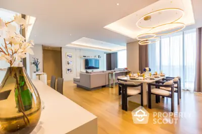 Luxurious open-plan living and dining area with modern decor and elegant lighting.