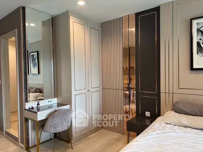 Luxurious bedroom with elegant decor and built-in wardrobe, featuring a stylish vanity and plush bedding.