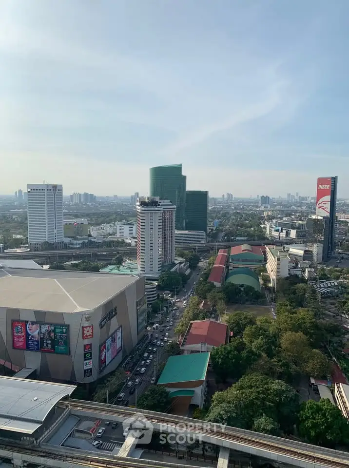 Stunning cityscape view from high-rise building showcasing urban skyline and lush greenery.