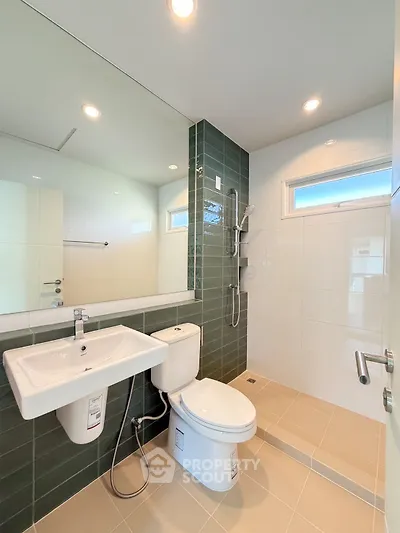 Modern bathroom with sleek fixtures and stylish green tile accents