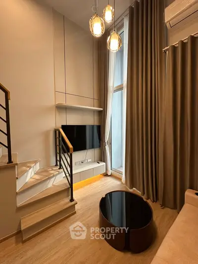 Modern living room with high ceilings, elegant lighting, and stylish staircase in a contemporary apartment.