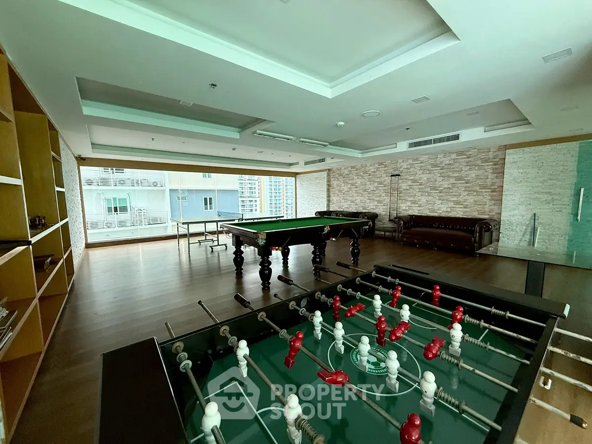 Luxurious recreation room with pool and foosball tables, ideal for entertainment and relaxation.