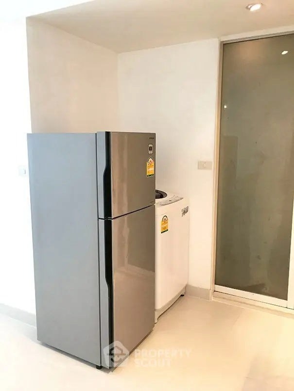 Modern kitchen corner with sleek fridge and washing machine