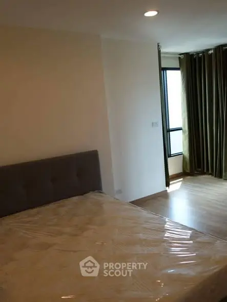 Cozy bedroom with natural light and modern decor, featuring a comfortable bed and elegant curtains.