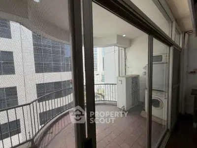 Spacious balcony with city view and laundry area in modern apartment