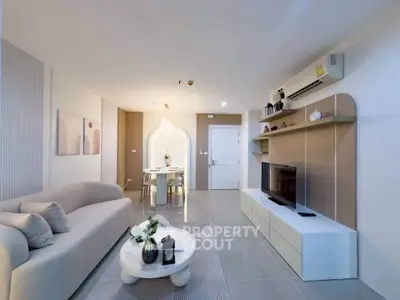 Modern living room with stylish decor and open dining area, featuring sleek furniture and ambient lighting.