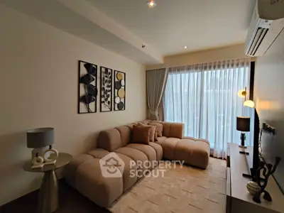 Modern living room with stylish decor and cozy seating area, featuring large windows and elegant lighting.