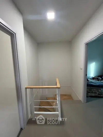 Modern interior hallway with wooden staircase and bright lighting
