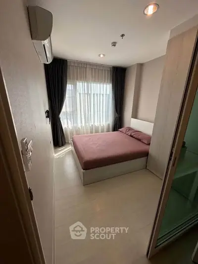Cozy bedroom with natural light and modern furnishings in a stylish apartment.