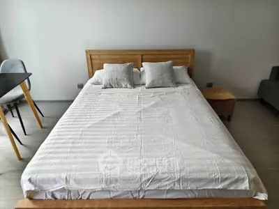 Modern bedroom with wooden bed frame and cozy decor in a stylish apartment.