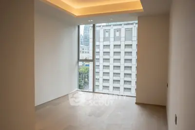 Spacious empty room with large window and city view, perfect for customization.