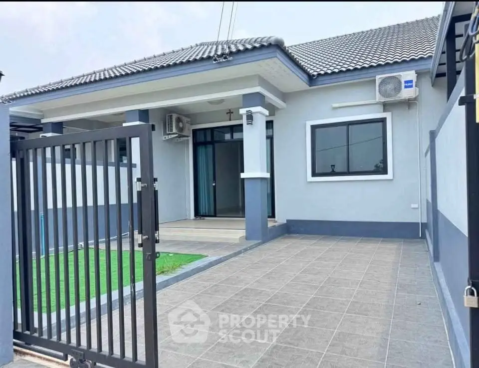 Charming single-story home with modern facade and gated entrance, featuring air conditioning and tiled patio.