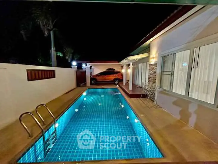Luxurious night view of private villa with illuminated swimming pool and modern design.