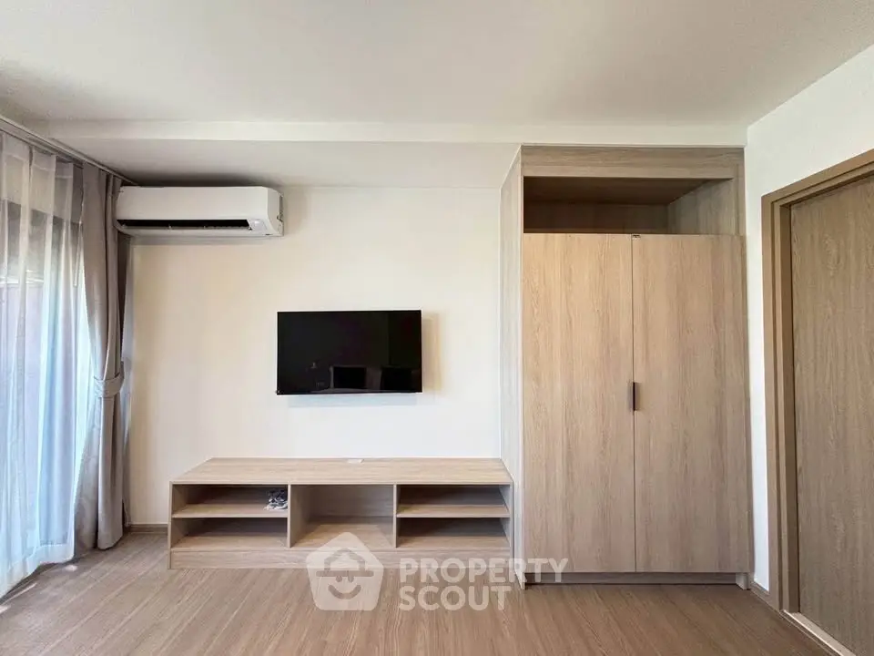 Modern living room with sleek TV setup and stylish wooden cabinetry.