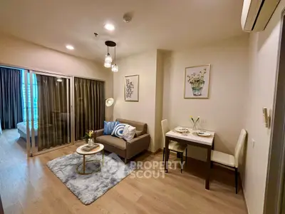 Modern living room with cozy decor and dining area in open layout apartment.