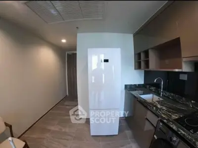 Modern kitchen with sleek appliances and marble countertops in a contemporary apartment.