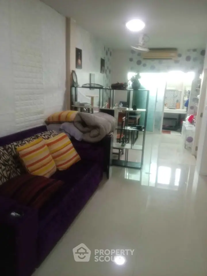 Cozy living room with modern decor and open layout leading to kitchen area.