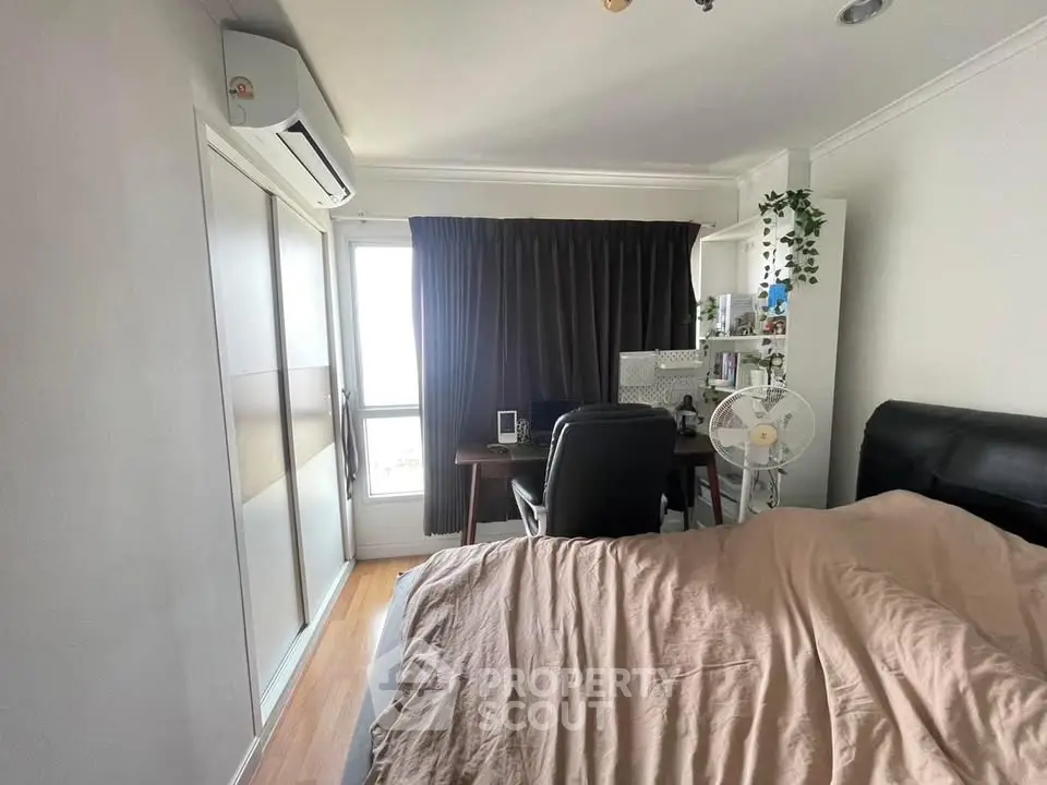 Cozy bedroom with study area, featuring a comfortable bed and modern decor.