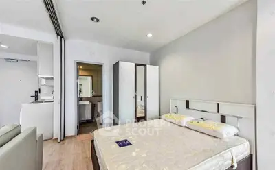 Modern bedroom with ensuite bathroom in a stylish apartment, featuring sleek furniture and neutral tones.