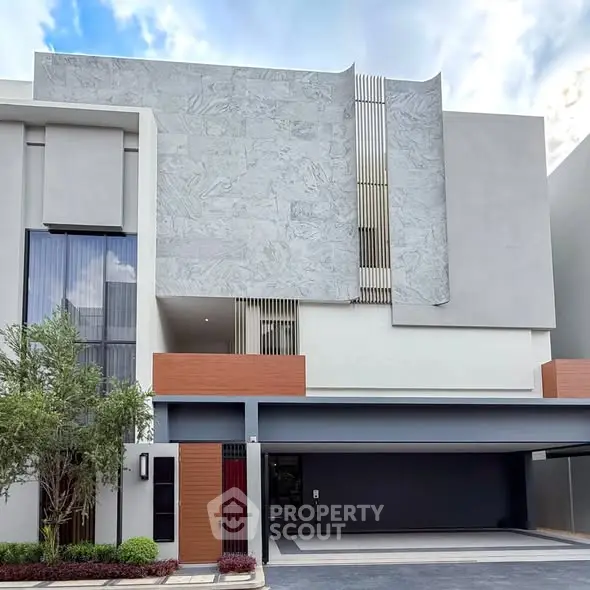 Modern architectural facade of a luxury residential building with sleek design and spacious garage.