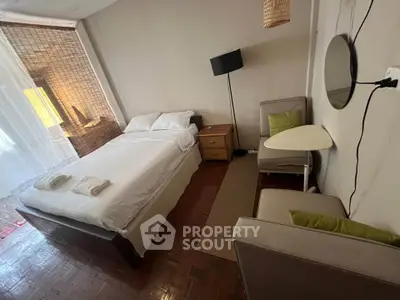 Cozy bedroom with modern decor and natural light, featuring a comfortable bed and stylish furnishings.