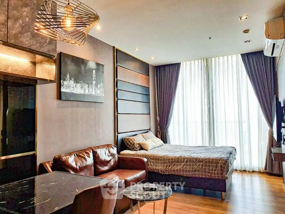 Modern studio apartment with stylish decor and large windows in urban setting.