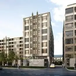 Modern urban apartment complex with sleek architectural design and street view.