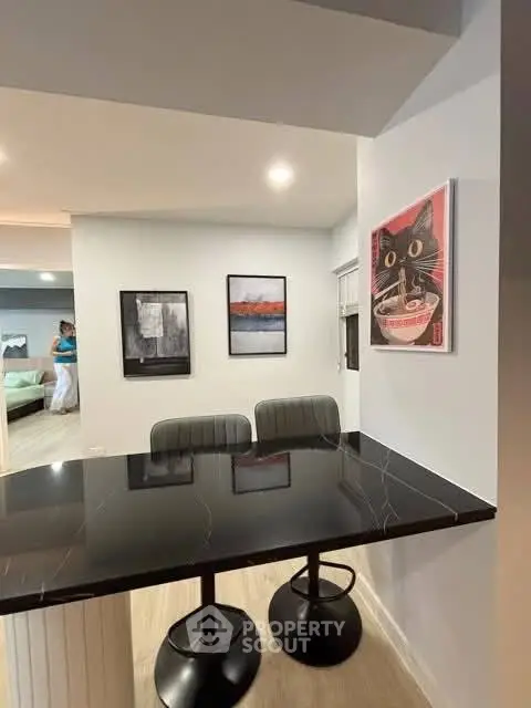 Modern kitchen with sleek black countertop and stylish bar stools