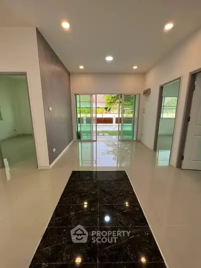 Spacious modern living room with glossy tile flooring and large windows.