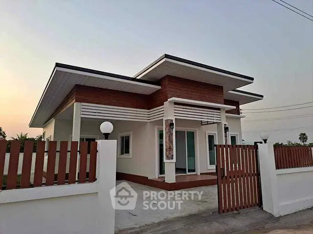 Modern single-story house with stylish facade and spacious front yard.