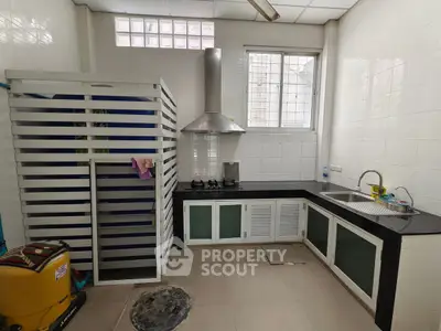 Modern kitchen with sleek black countertops and gas stove in a bright, airy space.