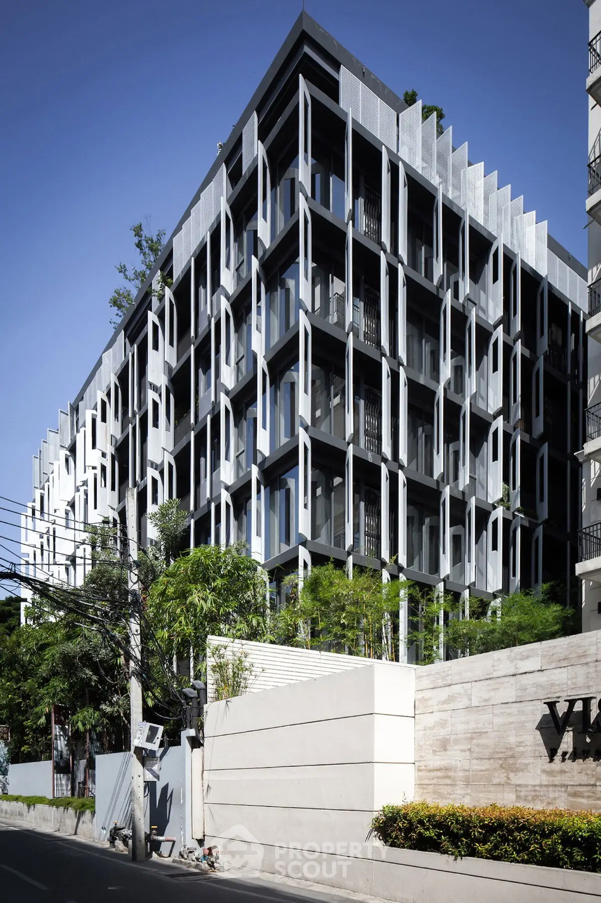 Modern architectural building with unique facade design and lush greenery